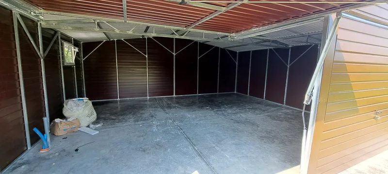 Plechová garáž 7 × 6 m s dvoma bránami, dverami a oknom, fotografia realizácie 9
